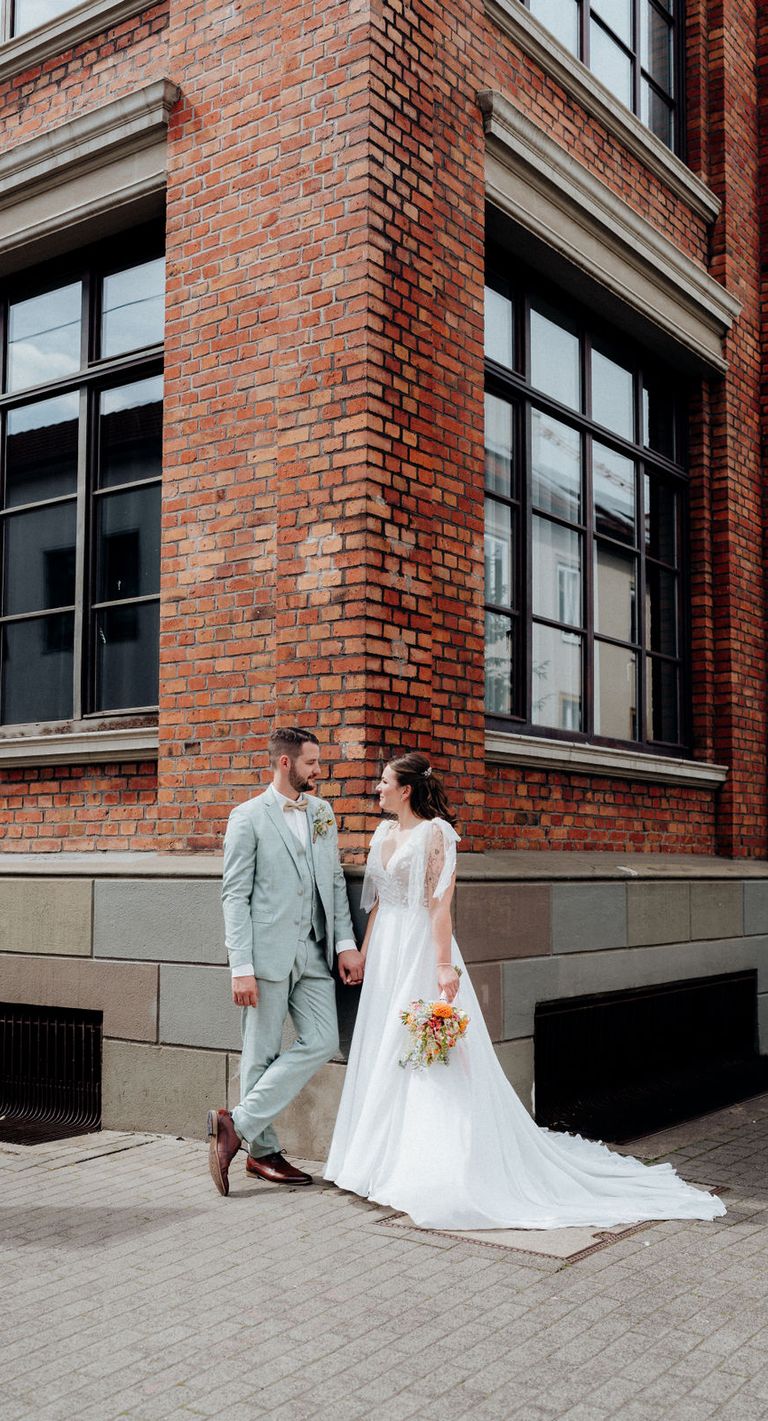 Braut und Bräutigam bei standesamtlicher Hochzeit in Bielefeld vor Backsteingebäude